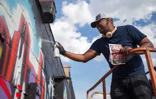 Street artist muralist Corey Barksdale painting for the Rockford, Illinois CRE8IV festival